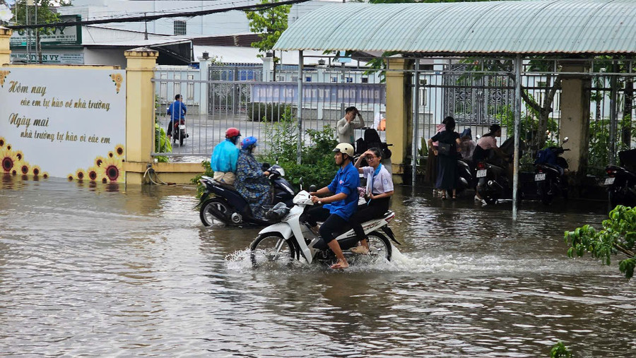 Lực lượng thanh nhiên tình nguyện đã dùng xe gắn máy để chở các em từ ngoài cổng trường vào phòng thi an toàn. Ảnh: Minh Hoàng. z6743888889642-23430b96de5c978944a1443dc2c88ff2.jpg
