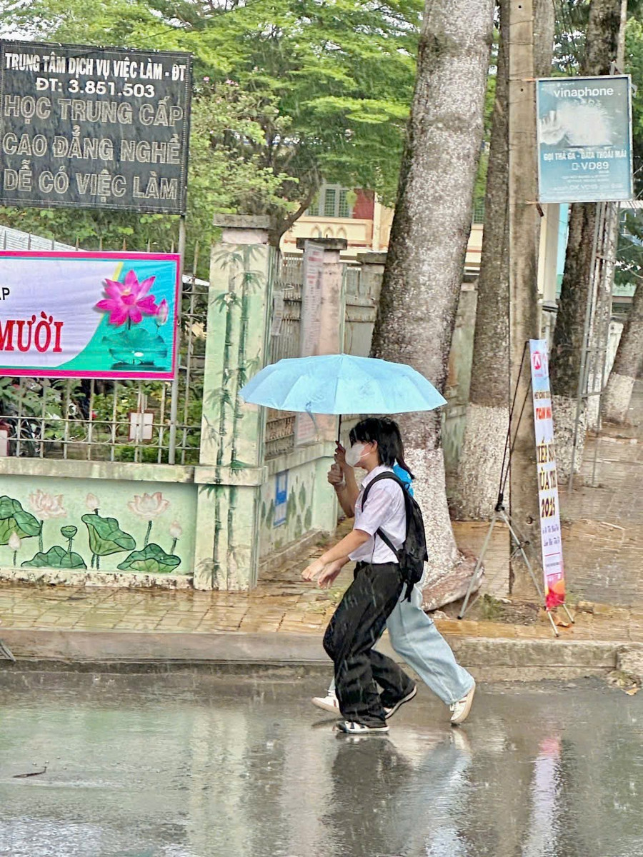 Tình nguyện viên dầm mưa hỗ trợ thí sinh tại TP Sa Đéc, tỉnh Đồng Tháp. Ảnh: Minh Hoàng. img-1750936524213-1750986012739.jpg