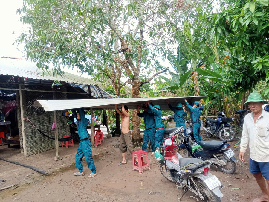 Lực lượng chức năng hỗ trợ người dân khắc phục nhà bị thiệt hại.