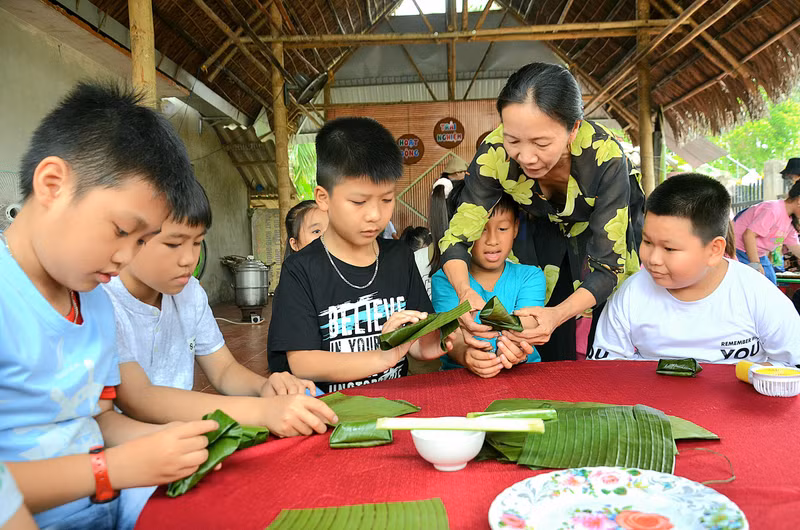 Các em được trải nghiệm dưới dự hướng dẫn của những người dân có kinh nghiệm làm bánh lâu năm ở Bình Thành. Học sinh thích thú trải nghiệm làm bánh truyền thống ở làng du lịch
