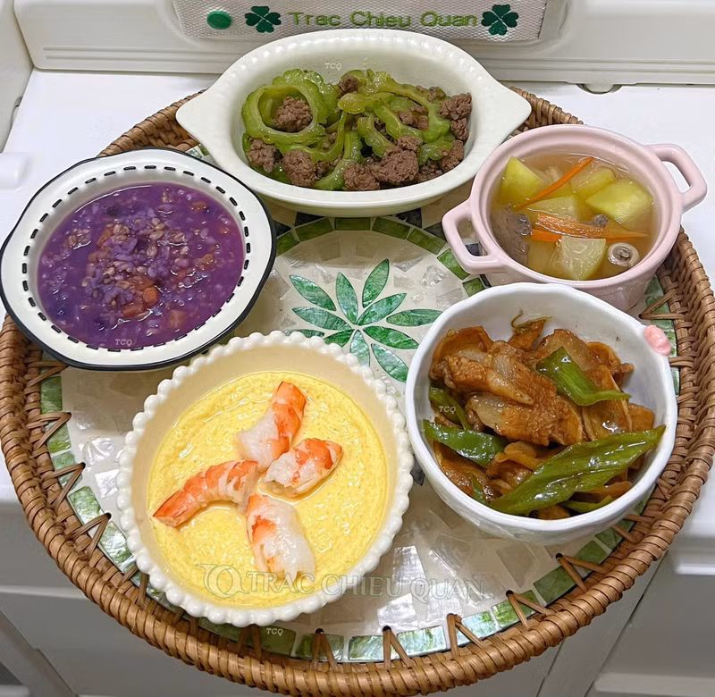 Mướp đắng xào thịt bò, Trứng hấp tôm, Thịt lợn xào ớt + củ niễng, Canh tim lợn đu đủ, Cháo ngũ cốc khoai tím. Mâm cơm cữ chồng nấu chăm vợ sau sinh khiến hội chị em ngưỡng mộ