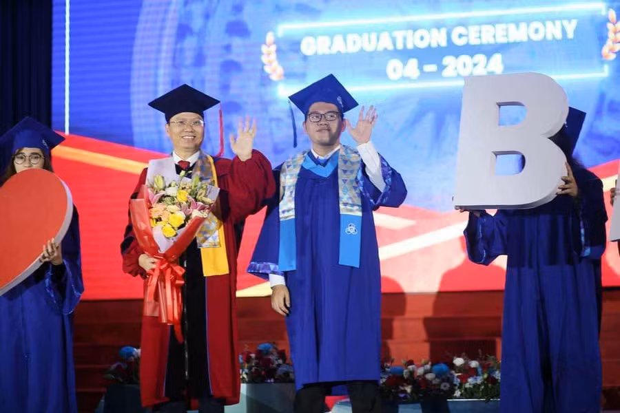 Thái Tài cùng thầy hiệu trưởng tại lễ tốt nghiệp. (Ảnh: NCVV).