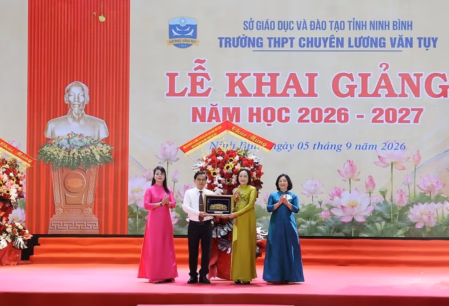 Phó Chủ tịch Quốc hội Nguyễn Thị Thanh tặng hoa và quà lưu niệm là bức tranh Tòa nhà Quốc hội cho Trường THPT chuyên Lương Văn Tụy. Ảnh: Minh Quang