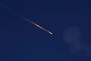 Một mảnh vỡ rơi xuống bầu trời sau khi hệ thống Iron Dome của Israel chặn được một tên lửa phóng từ Iran về phía Israel, trong bối cảnh xung đột Iran-Israel, nhìn từ Ashkelon, Israel. Ảnh: REUTERS