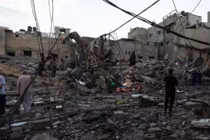 Người dân đang kiểm tra một tòa nhà bị phá hủy sau cuộc không kích của Israel tại Dải Gaza.