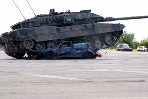 Các binh sĩ Đức trình diễn khả năng của xe tăng chiến đấu chủ lực Leopard 2A7V và lái xe cán qua một chiếc VW Golf cũ trong Ngày Quân đội trên khuôn viên Đại học Bundeswehr. 