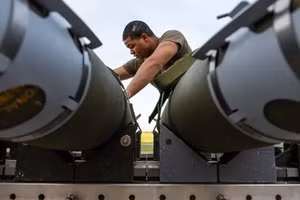 Một phi công của Phi đội máy bay ném bom thế hệ 393 đang chuẩn bị bom tấn công trực tiếp GBU-38 để lắp vào máy bay ném bom tàng hình B-2 Spirit.