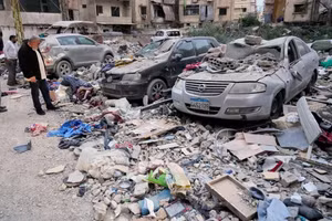 Người dân kiểm tra các mảnh vỡ rơi xuống những chiếc ô tô đỗ tại địa điểm một tòa nhà chung cư bị tấn công trong cuộc tấn công của Israel vào Dahiyeh, vùng ngoại ô phía nam của Beirut, Lebanon. Ảnh: AP.