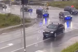 Một hàng dài xe bọc thép màu đen chạy nhanh trên đường, được hộ tống bởi những chiếc xe cảnh sát nhấp nháy ở Magadan, Viễn đông nước Nga.