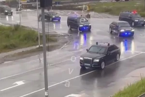 Một hàng dài xe bọc thép màu đen chạy nhanh trên đường, được hộ tống bởi những chiếc xe cảnh sát nhấp nháy ở Magadan, Viễn đông nước Nga.