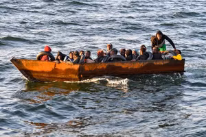 Người tị nạn từ vùng Hạ Sahara ngồi trên một chiếc thuyền tạm bợ bị lực lượng chức năng Tunisia chặn lại cách bờ biển thành phố Sfax khoảng 50 hải lý trên Địa Trung Hải.