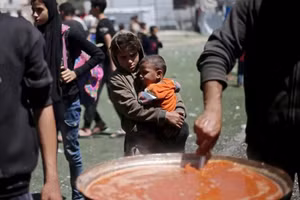 Trẻ em Palestine chờ trước điểm phân phối thực phẩm miễn phí để nhận phần ăn nóng của mình tại trại tị nạn Nuseirat ở trung tâm Gaza. Ảnh: AFP