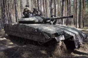 Quân nhân Ukraine trên xe chiến đấu CV90 của Thụy Điển trong rừng gần Kharkiv.