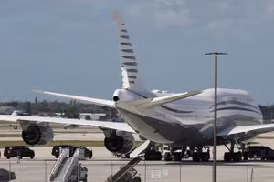 Đoàn xe hộ tống Tổng thống Mỹ Donald Trump đỗ cạnh chiếc Boeing 747-8 do Qatar sở hữu, đã 12 năm tuổi, mà Trump đang tham quan ở West Palm Beach, Florida, ngày 15/2/ 2025. Ảnh: REUTERS