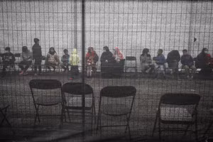 Người tị nạn Afghanistan xếp hàng bên ngoài một trung tâm phân phối và quyên góp tại Liberty Village thuộc Căn cứ chung McGuire-Dix-Lakehurst ở New Jersey, Hoa Kỳ. Ảnh: REUTERS/Barbara Davidson.