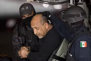 Cảnh sát liên bang Mexico áp giải người mà họ xác định là Servando “La Tuta” Gómez, thủ lĩnh băng Hiệp sĩ Đền thánh, khi ông ngồi bên trong trực thăng ở thành phố Mexico ngày 27/2/2015. (Ảnh AP/Eduardo Verdugo, tư liệu)