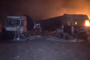 Lửa và khói bốc lên bên cạnh những chiếc xe bị cháy đen sau cuộc tấn công của Mỹ vào cảng nhiên liệu Ras Isa, Yemen, theo như những gì Al Masirah TV đưa tin. Ảnh: Reuters.