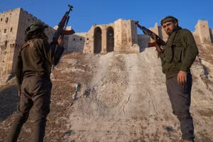 Chiến binh đối lập Syria chụp ảnh trước thành cổ Aleppo sau khi giành quyền kiểm soát thành phố Syria này ngày 1/12. Ảnh: Karam Almasri/Getty Images