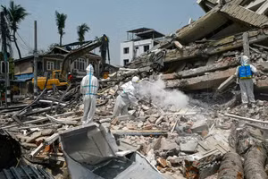 Các công nhân mặc đồ bảo hộ phun thuốc khử trùng tại đống đổ nát của một tòa nhà bị sập ở Mandalay, Myanmar sau trận động đất ngày 28/3. Ảnh: Sai Aung Main/AFP.