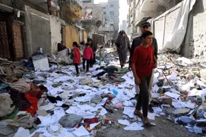 Người dân Palestine đi bộ tại địa điểm Israel không kích một ngôi nhà ở phía bắc Gaza ngày 18/4. Ảnh: Mahmoud Issa/Reuters.