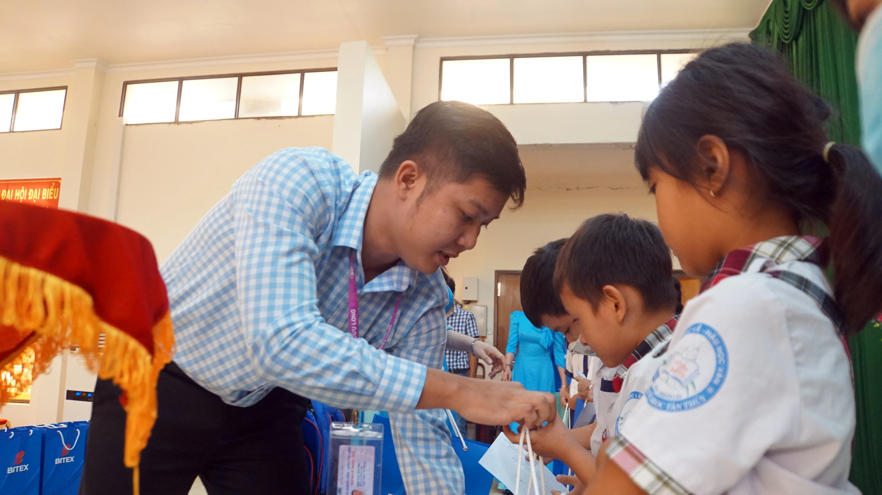 Ông Huỳnh Lê Phước Thọ, đại diện Trường Đại học Cửu Long trao quà cho học sinh tiểu học. Ảnh: Mạnh Tùng