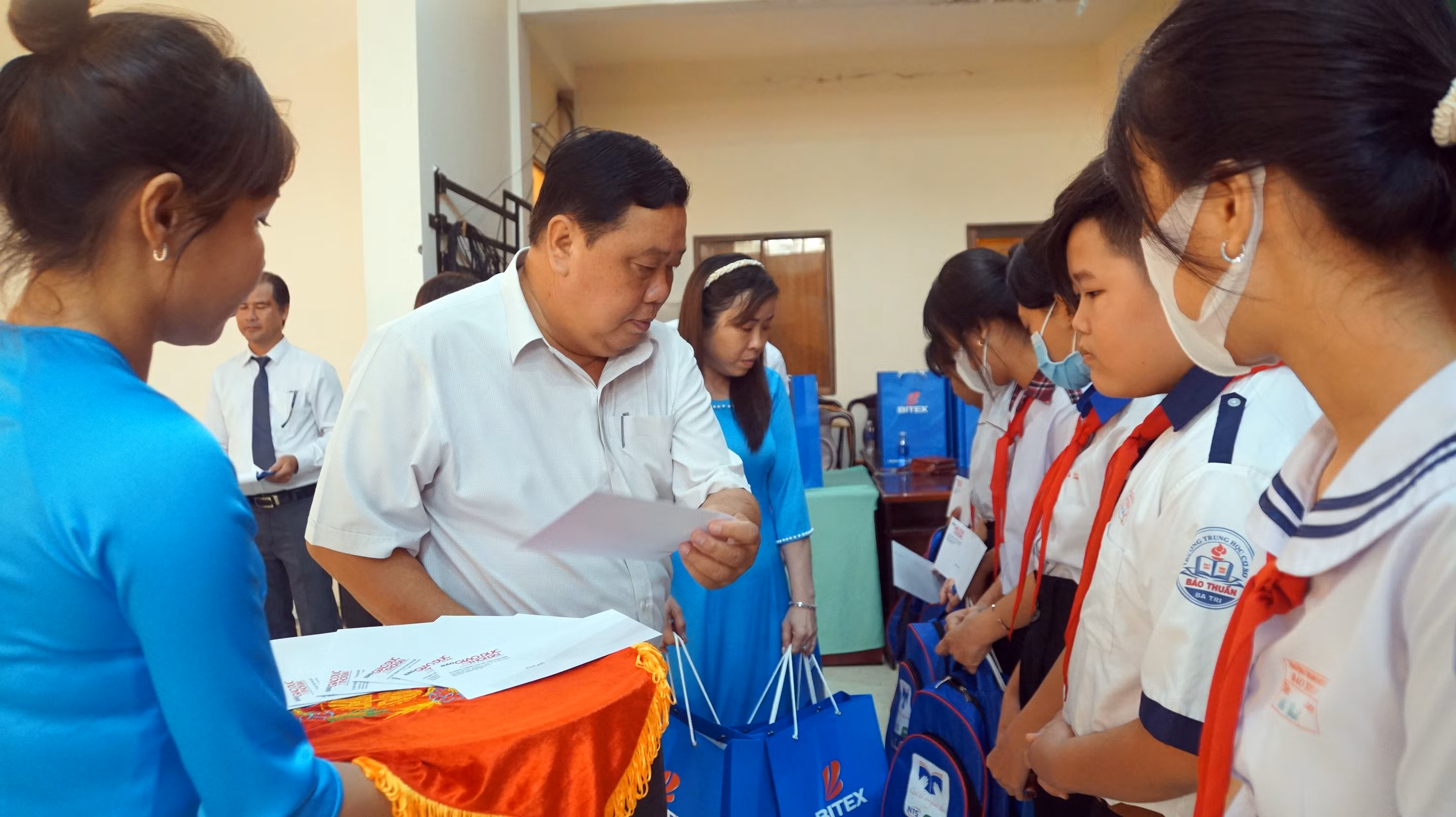 Ông Trần Văn Hoàng, Phó Chủ tịch UBND huyện Ba Tri trao học bổng cho học sinh vượt khó học giỏi. Ảnh: Mạnh Tùng