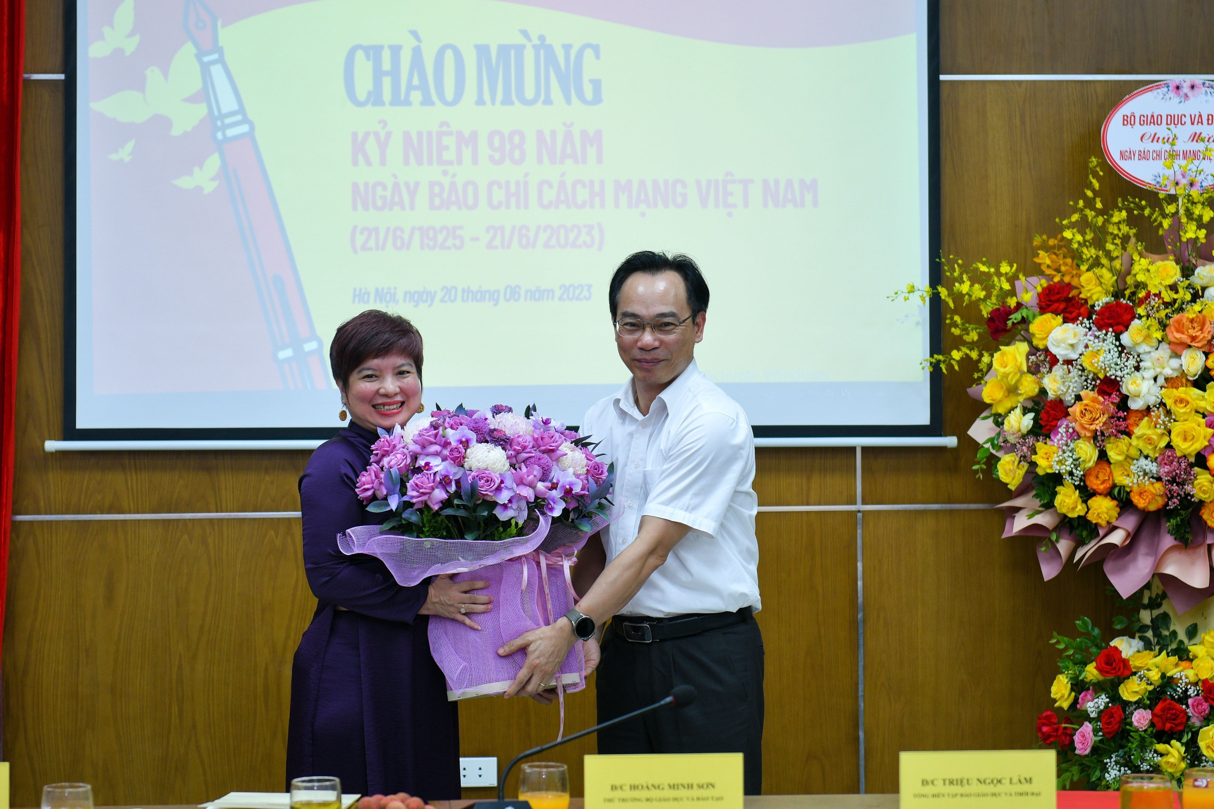 Thứ trưởng Hoàng Minh Sơn tặng hoa chúc mừng nhà báo Dương Thị Thanh Hương.