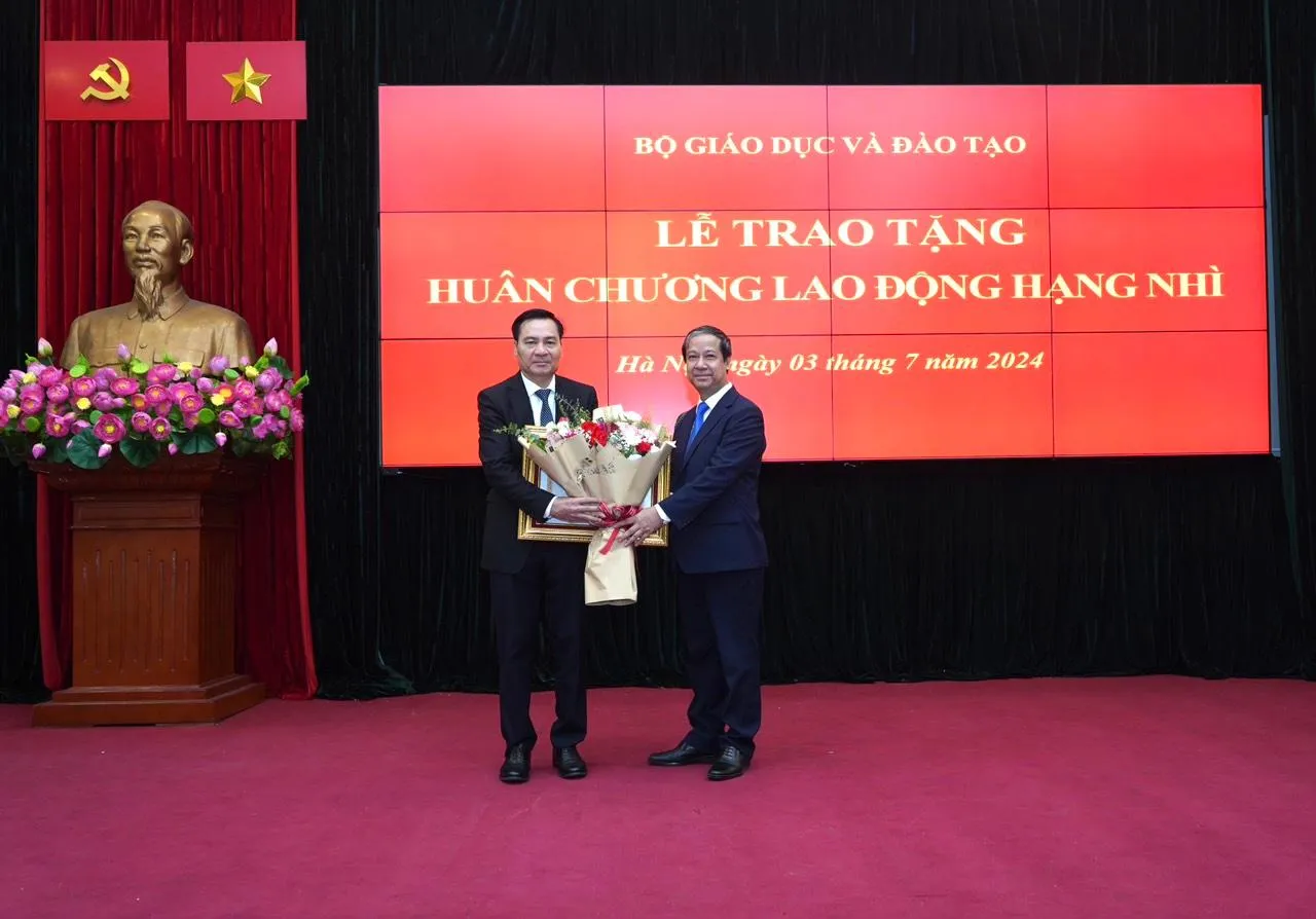 Bộ trưởng Nguyễn Kim Sơn trao Huân chương và tặng hoa chúc mừng ông Phạm Như Nghệ.
