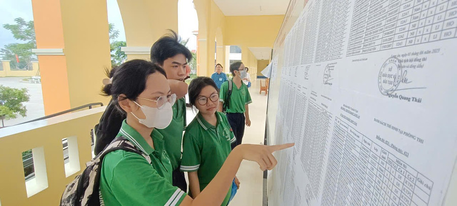 Những thí sinh đầu tiên đến điểm thi đang coi số phòng thi. (Ảnh: Quốc Hải) 4886f4d0dd196a473308.jpg