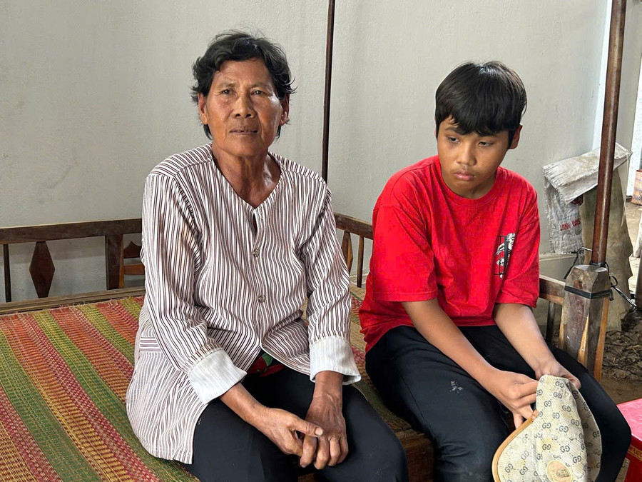 Em Dụng Minh Thiên cùng bà ngoại tại ngôi nhà lá của mình. (Ảnh: Trần Quỳnh). dung-minh-thien.jpg