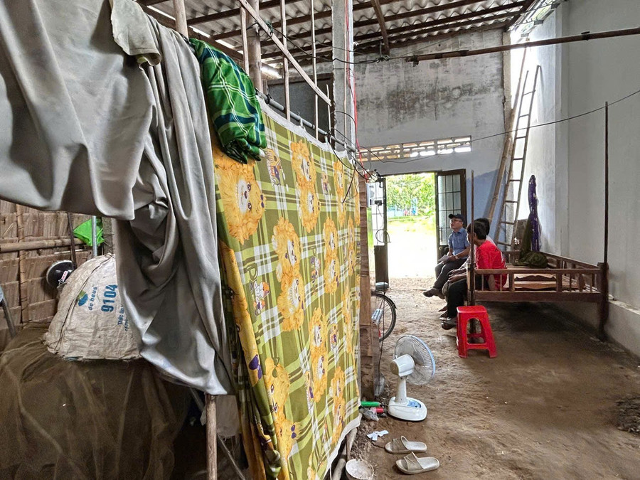 Bức tường mượn tạm hàng xóm một bên, bên còn lại lợp bằng tre, lá của nhà em Dụng Minh Thiên. (Ảnh: Trần Quỳnh). thien-1.jpg