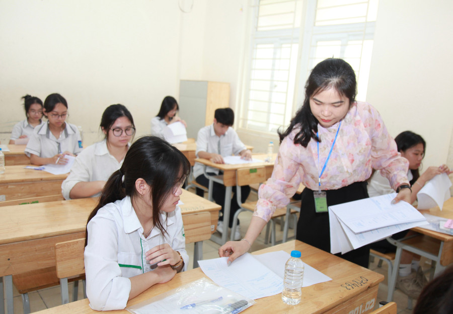 Giám thị phát giấy nháp thi cho các thí sinh.