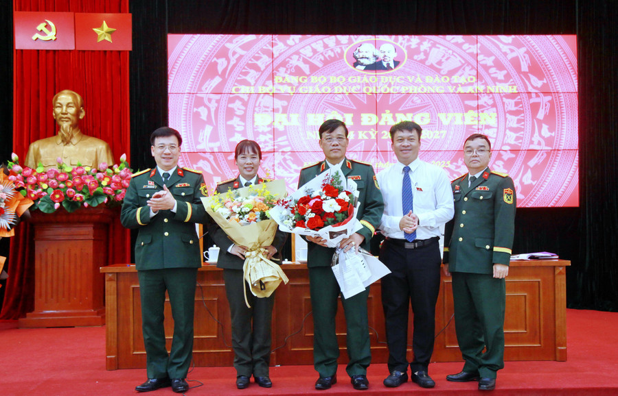 Đại tá Đồng Quang Việt, Phó trưởng Phòng Cán bộ, Cục Chính trị, Bộ Tổng tham mưu, Bộ Quốc phòng (bên trái) và ông Doãn Hồng Hà - Phó Trưởng Ban Tuyên giáo và Dân vận Đảng ủy Bộ GD&ĐT (áo trắng) tặng hoa chúc mừng Chi ủy Vụ GDQPAN, nhiệm kỳ 2025 -2027. img-0319.jpg