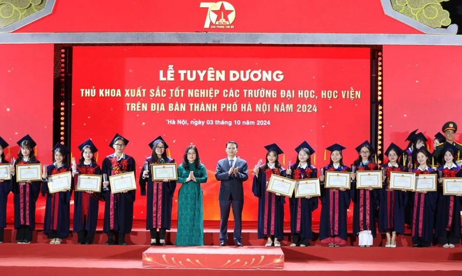 Thứ trưởng Bộ GD&ĐT Nguyễn Thị Kim Chi và Phó Chủ tịch HĐND thành phố Hà Nội Phạm Quí Tiên trao Bằng khen thủ khoa xuất sắc. 