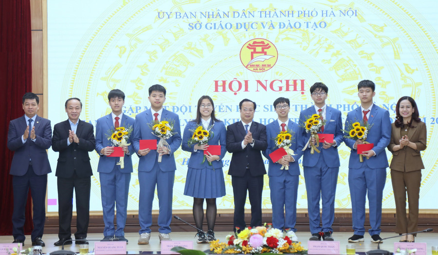 Phó Chủ tịch Thường trực HĐND thành phố Trần Thế Cương và lãnh đạo Sở Giáo dục và Đào tạo Hà Nội tặng hoa động viên các em học sinh.