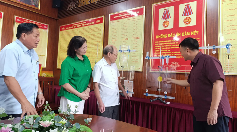 Thầy Nghiêm Hồng Trung (bên phải) giới thiệu về Bộ dụng cụ thí nghiệm Tổng hợp lực, Moment lực dùng trong dạy học tìm tòi khám phá. img-27.jpg