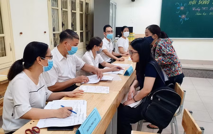 Giáo viên hỗ trợ phụ huynh đăng ký tuyển sinh trực tuyến.