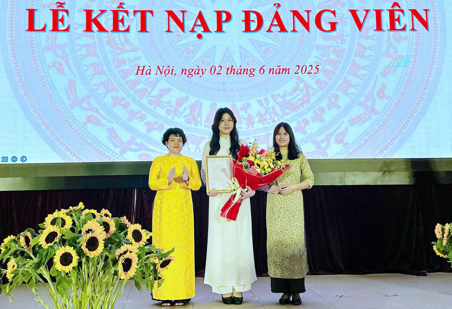 Bí thư Đảng ủy Trần Thùy Dương tặng hoa chúc mừng tân đảng viên Đỗ Khánh Huyền. knd4.jpg