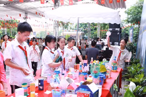 Học sinh tham quan gian trưng bày các đồ dùng từ vật liệu tái chế nhằm giảm thiểu rác thải nhựa.