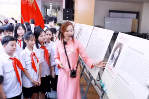 Học sinh cùng tham quan triển lãm ảnh "Sen trong đá" tại Trường THCS Ngô Sĩ Liên. Ảnh: Đình Tuệ.