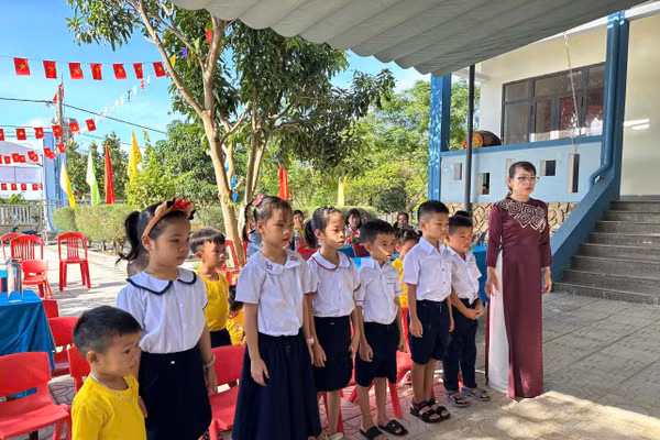 Học sinh đảo Cồn Cỏ hát quốc ca cùng cô giáo trong lễ khai giảng.
