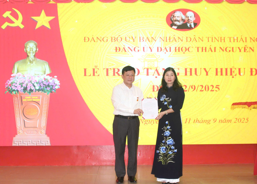 Bà Mai Thị Nhài, Phó Bí thư chuyên trách Đảng uỷ UBND tỉnh Thái Nguyên trao quyết định tặng huy hiệu Đảng cho PGS.TS Hoàng Văn Hùng.