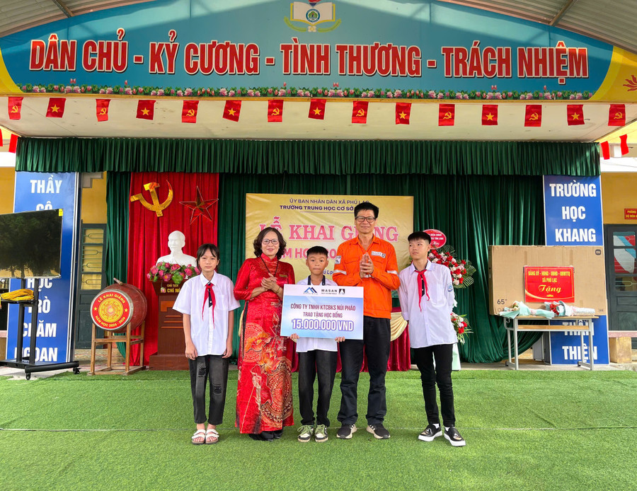 Đại diện Công ty TNHH Khai thác Chế biến Khoáng sản Núi Pháo trao quà cho các em học sinh. 