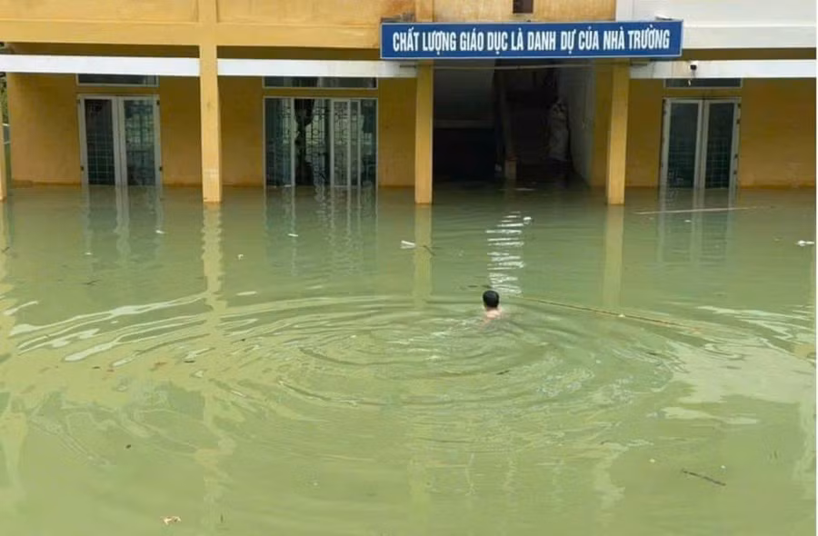 Thầy Hoàng Quốc Việt Hiệu trưởng trường Tiểu học Quang Vinh bơi trong dòng nước lũ đến trường kiểm tra.jpg