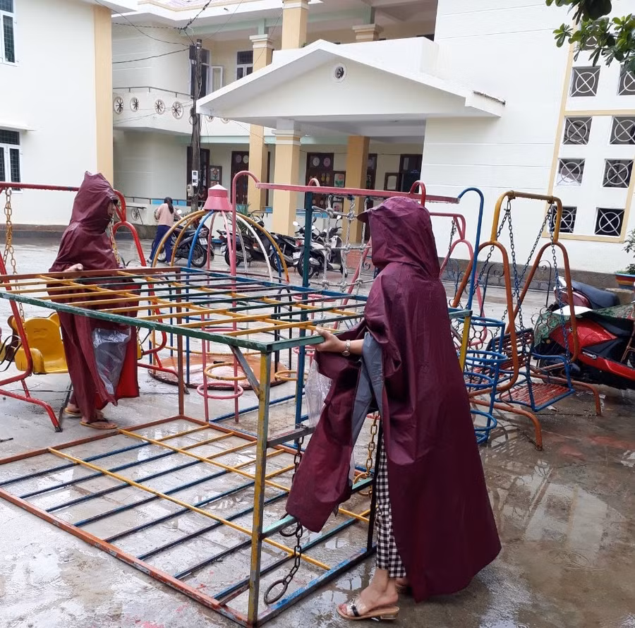 Giáo viên trường Mầm Non Lê Hoá (Tuyên Hoá - Quảng Bình) thu dọn đồ chơi ngoài trời để bảo vệ tài sản trong quá trình mưa bão.