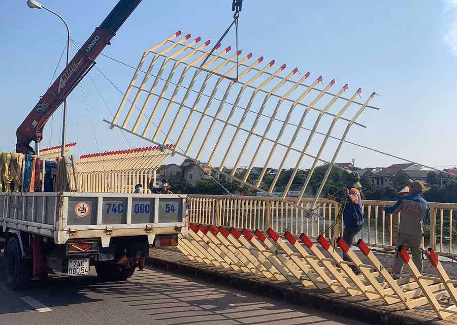 Các công nhân tiến hành tháo dỡ dàn lan can trang trí cầu Đại An giữa trưa nắng.