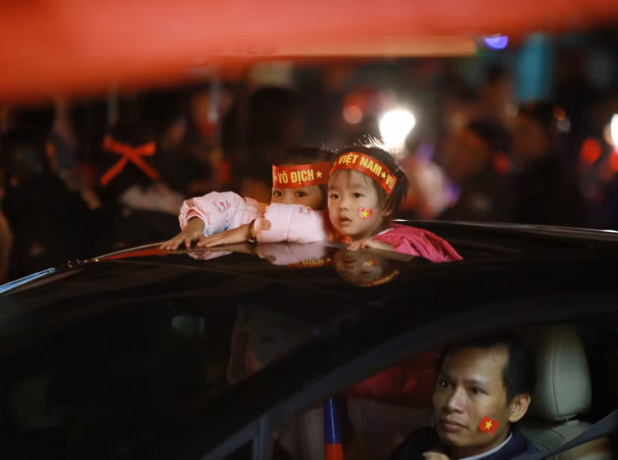 Bố chăm chú lái xe còn những đứa trẻ bỡ ngỡ trước biển người xuống đường mừng chiến thắng
