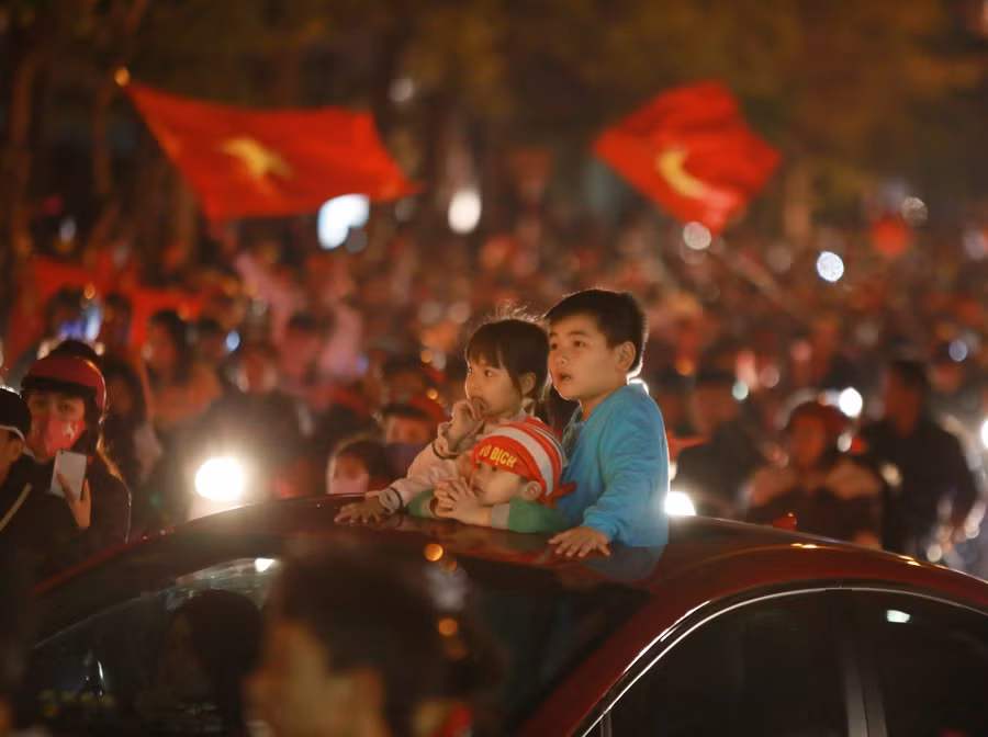 Những đứa trẻ giữa biển người xuống đường chúc mừng chiến thắng của đội tuyển bóng đá Việt Nam