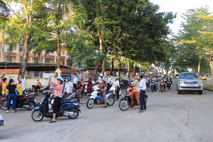 Phụ huynh đưa con em đến điểm thi. Phụ huynh đưa con em đến điểm thi.