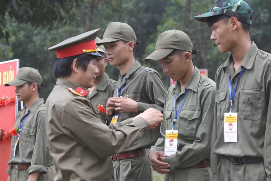 Ông Hoàng Xuân Thủy - Phó giám đốc Sở GD&ĐT tỉnh Quảng Trị tặng hoa điểm 10 cho những học sinh hoàn thành xuất sắc phần thi bắn đạn thật tại hội thao.